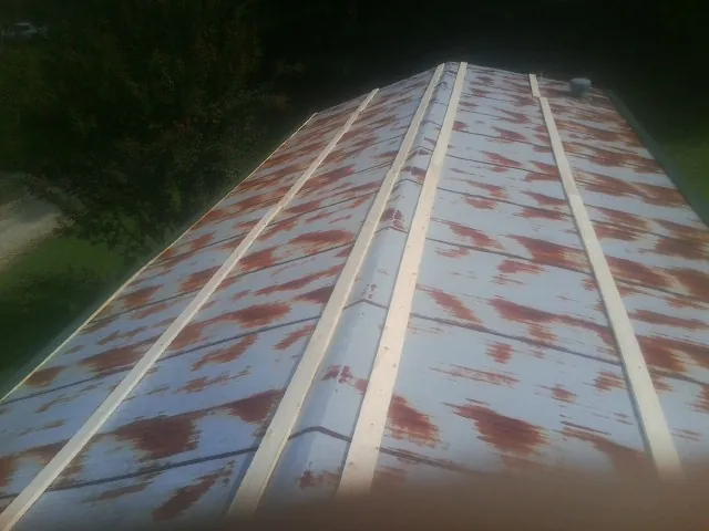 Rusted metal roof panels with new wood purlins before replacement — Storm Damage Roof Repair in Saint James by Roofing Brothers
